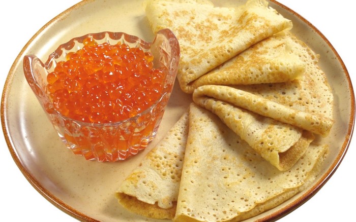 Pancakes with red caviar on a plate
