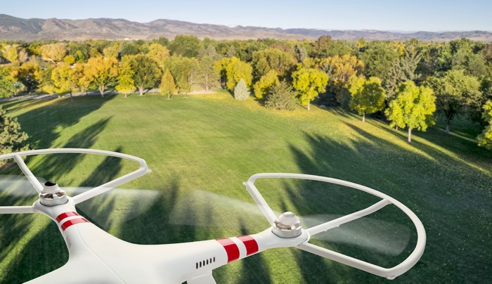 Drone flying over park with autumn trees