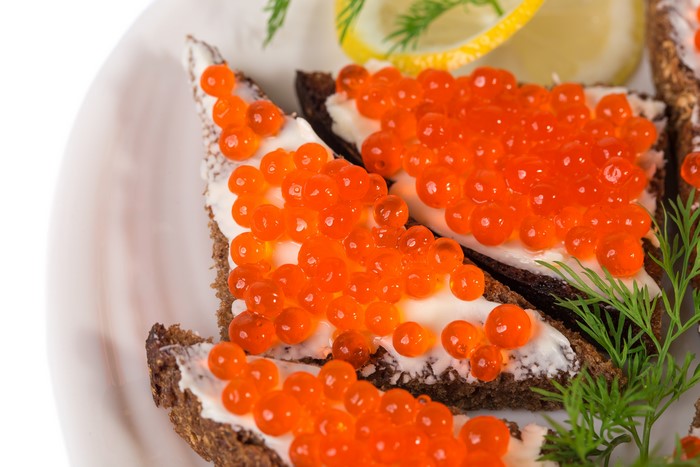 Caviar on rye bread with dill and lemon