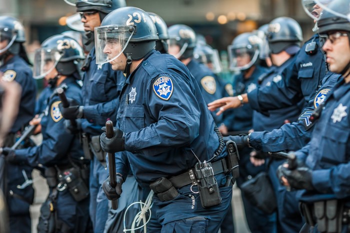 Oakland Police officers in riot gear holding batons