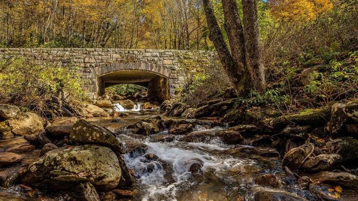 Stone bridge over a stream in autumn