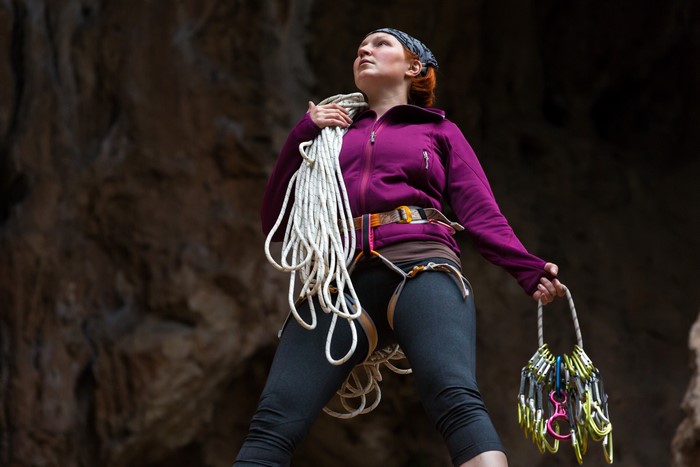 Woman with climbing gear in a cave