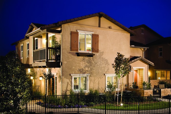 Two-story house at night with fence