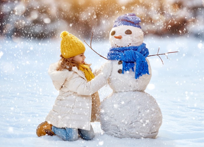 Girl Building a Snowman in Winter