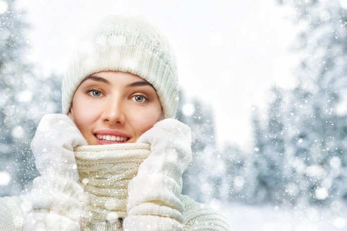 Woman in winter hat and scarf in snow