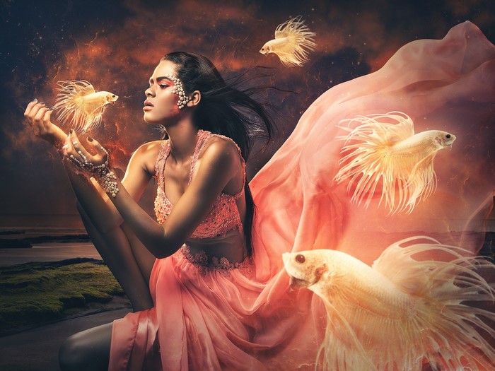 Woman in pink dress with Siamese fighting fish