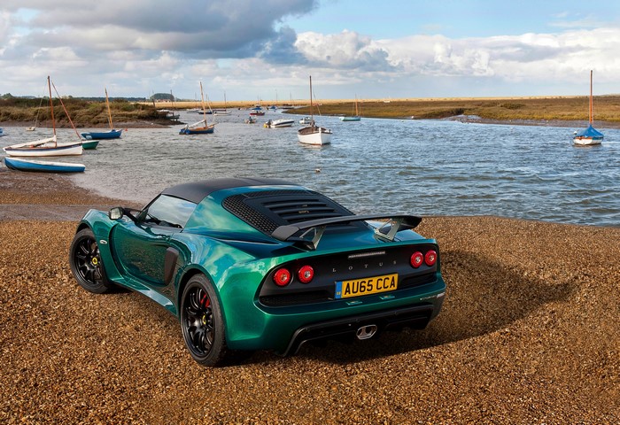Green Lotus Exige Sport 350 on a beach with boats