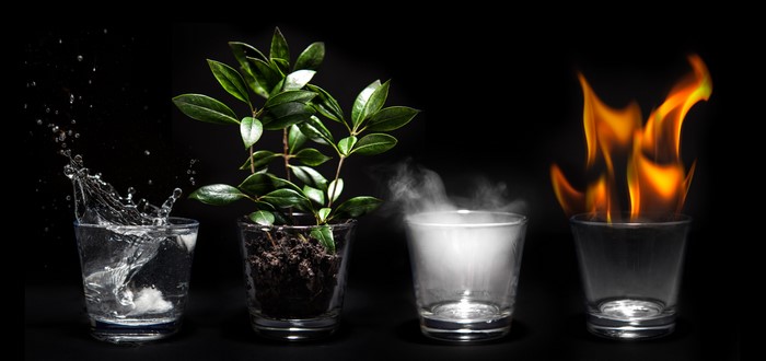 Four elements: water, earth, air, and fire in glasses