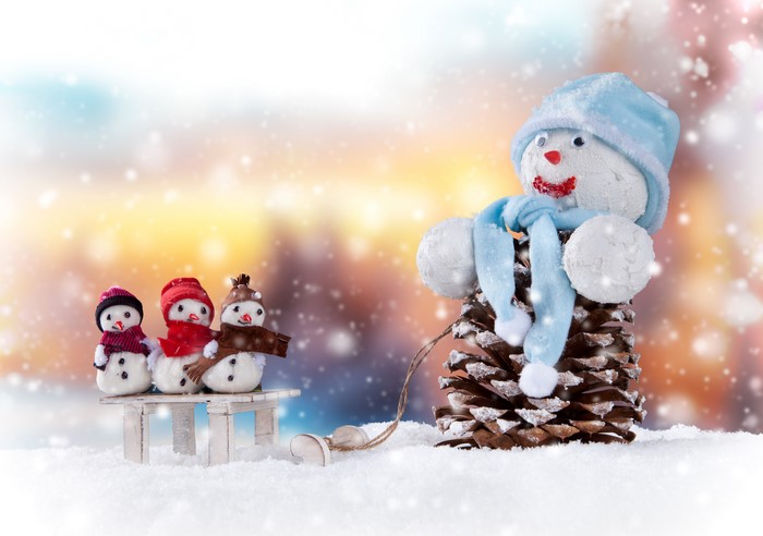Snowmen on a sled pulled by a pine cone snowman
