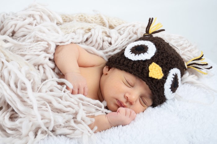 Baby sleeping in owl hat