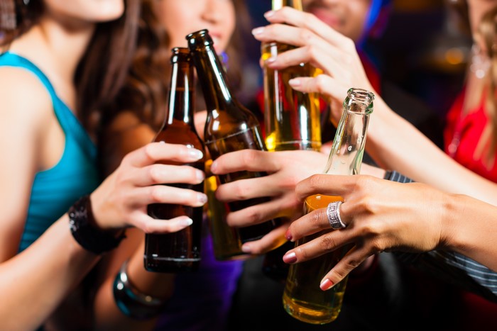 People toasting with beer bottles