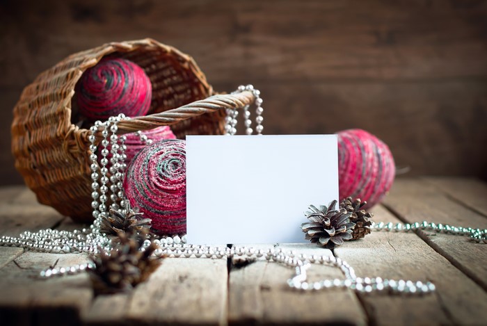 Christmas balls in a basket with pine cones and a greeting card