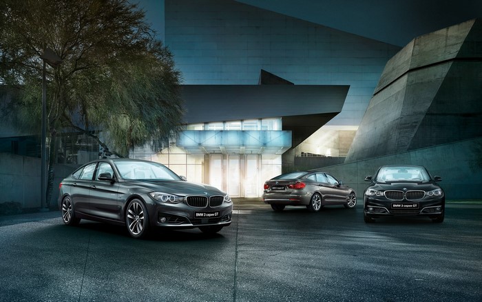 Three BMW 3 Series Gran Turismo cars parked outside a modern building