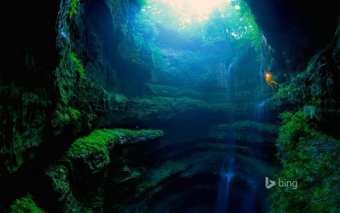 Cave explorer rappels down a waterfall in Neversink Pit