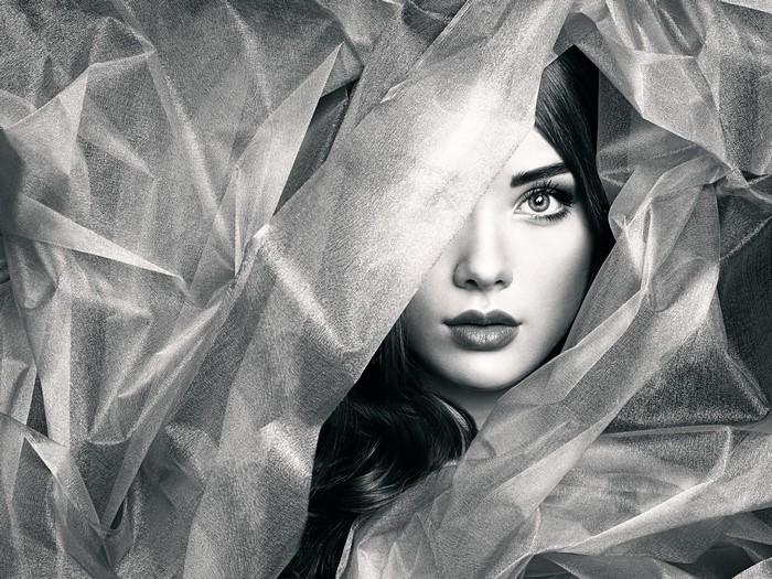 Woman peeking through sheer fabric