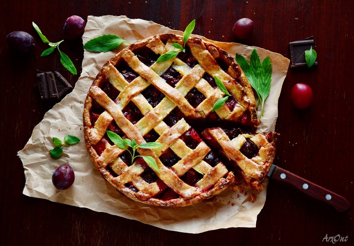 Plum pie with lattice crust and mint leaves