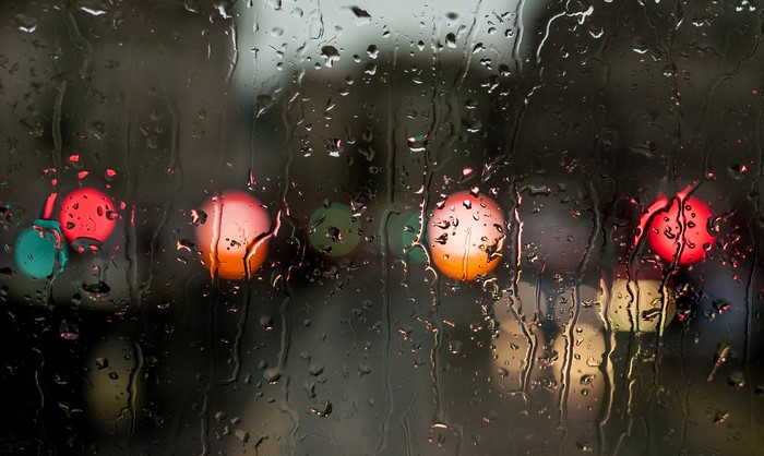 Raindrops on glass with blurred colorful lights
