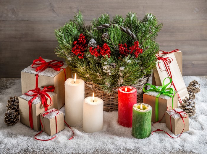 Christmas gifts, candles, and pine branches with snow