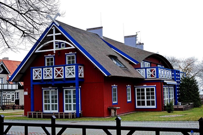 Red wooden house with blue trim in Nida, Lithuania
