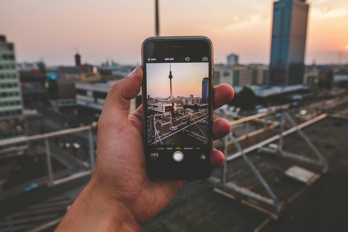 Person holding iPhone taking picture of Berlin TV Tower