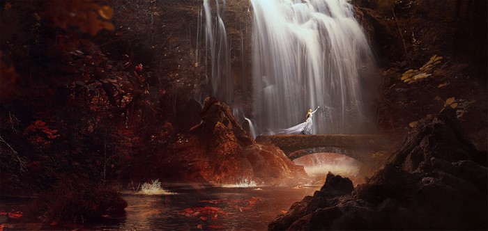 Woman in a dress on a bridge near a waterfall