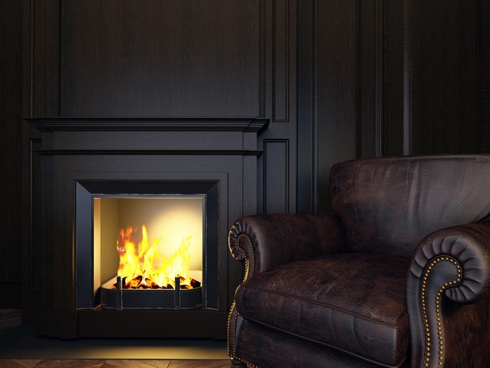 Fireplace and leather armchair in a dark room