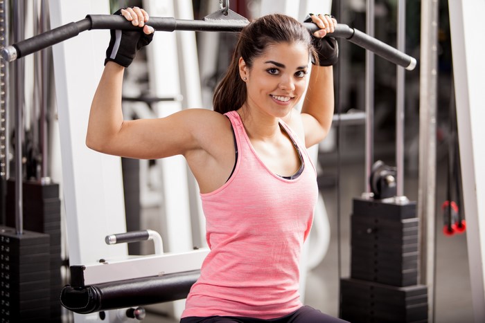 Woman working out on a lat pulldown machine
