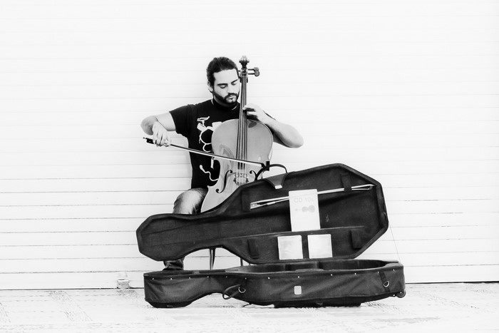 Man playing cello with open case