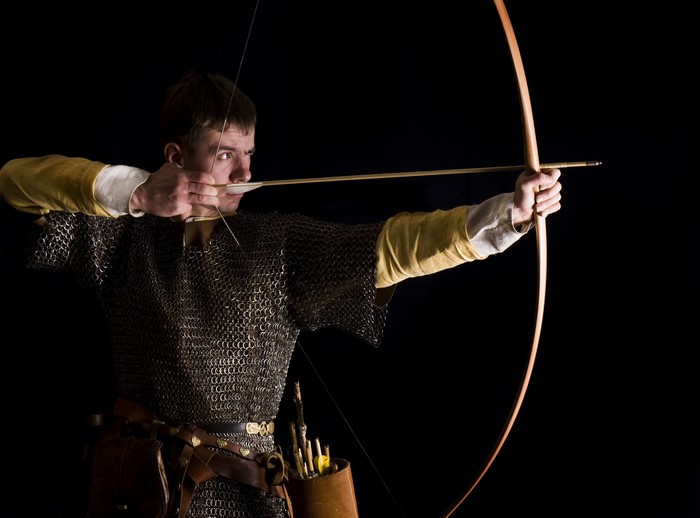 Medieval archer in chainmail aiming a bow