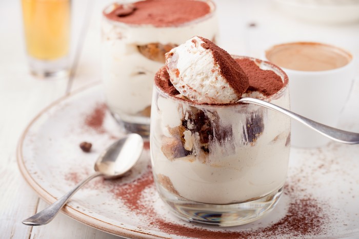 Tiramisu dessert in glasses with spoons and coffee