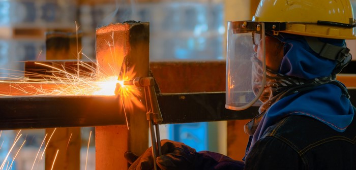 Worker welding metal with sparks flying