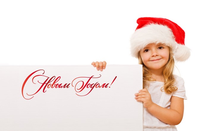 Little girl in Santa hat holding a sign with text