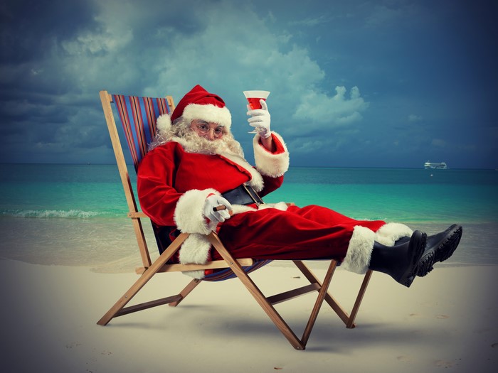Santa Claus relaxing on a beach with a drink