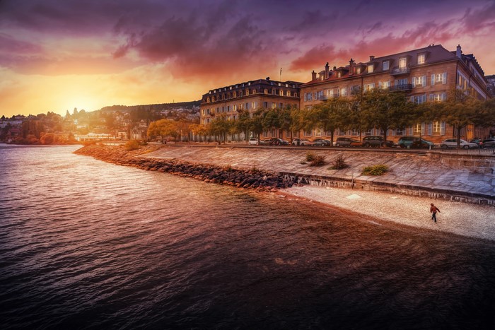 Buildings by the water at sunset