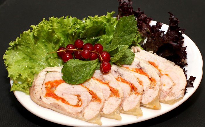 Meat roll with vegetables and berries on a plate