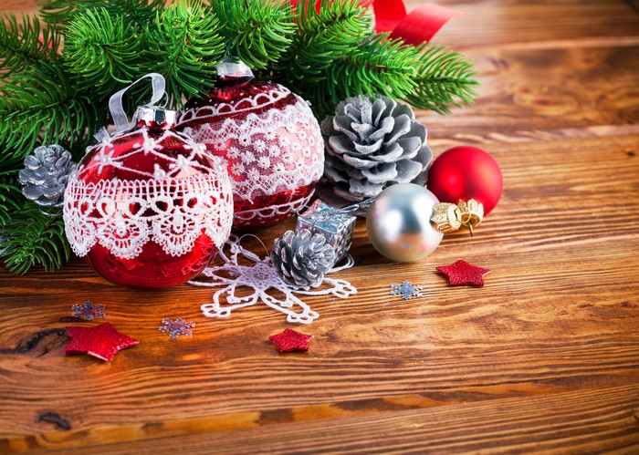 Christmas ornaments and pine cones on wooden background