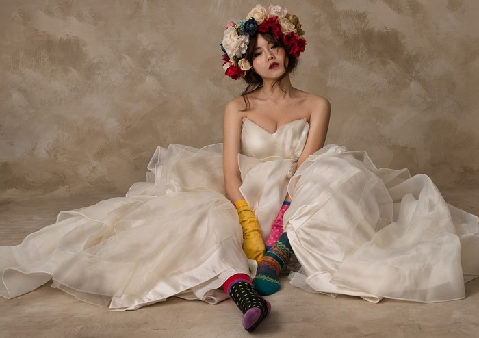 Asian woman in wedding dress with flower crown and colorful socks