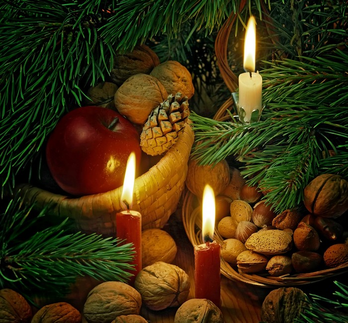 Christmas still life with candles, apple, nuts, and pine branches