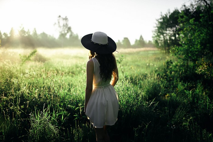Woman in a hat in a grassy field