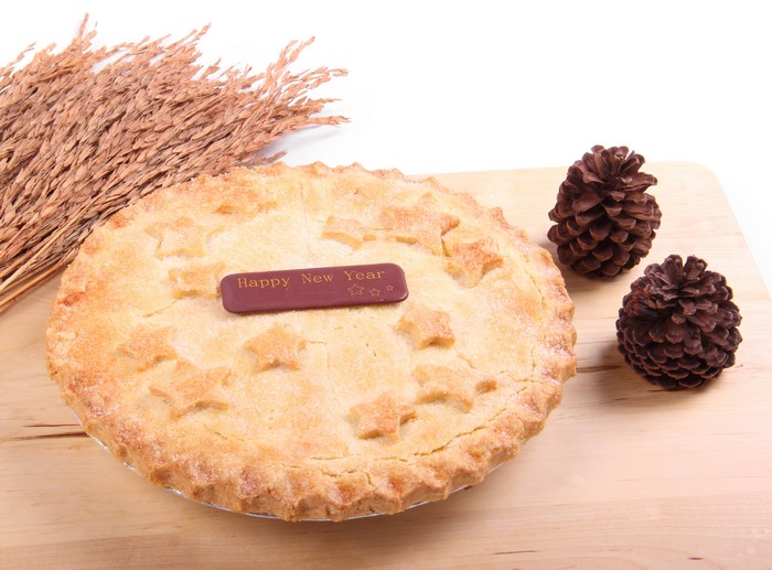 Pie with Happy New Year decoration and pine cones
