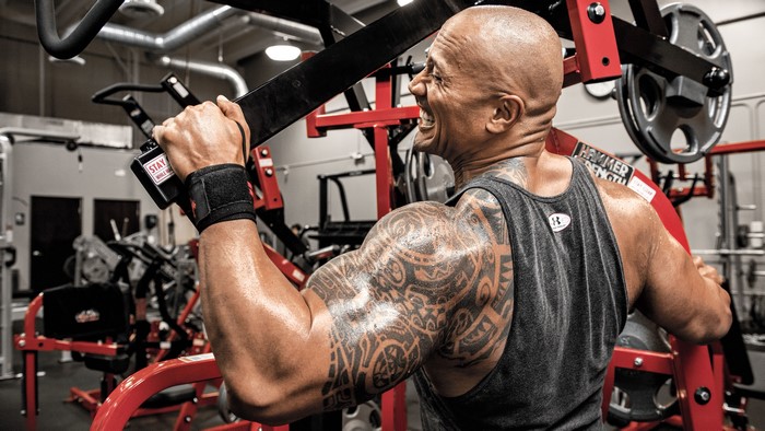 Dwayne Johnson working out on a machine