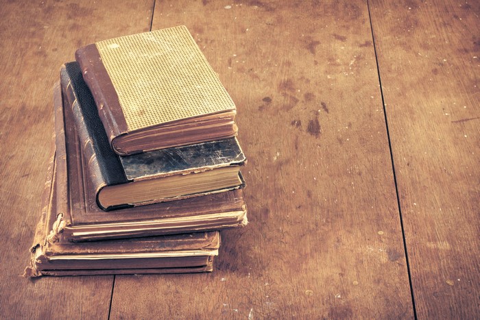 Stack of old books on a wooden table