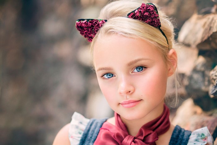 Young girl with blonde hair and blue eyes wearing cat ears