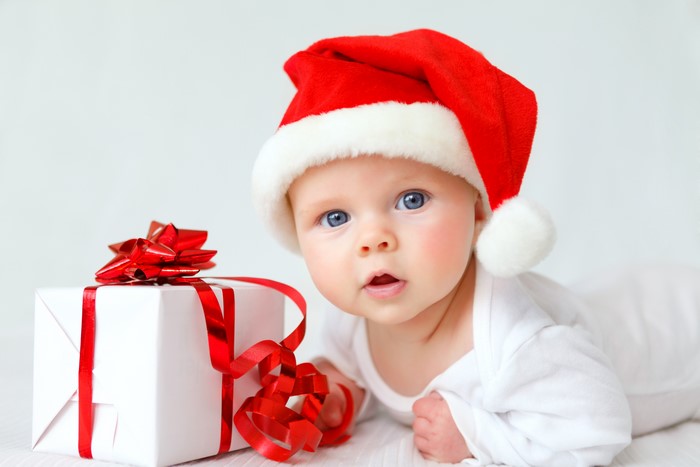 Baby in Santa hat with Christmas gift