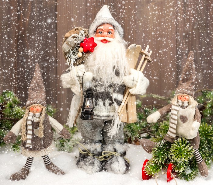 Santa Claus with two elf dolls in the snow