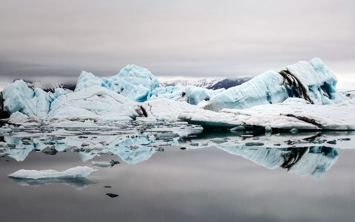 Icebergs floating in glacial lagoon with mountains