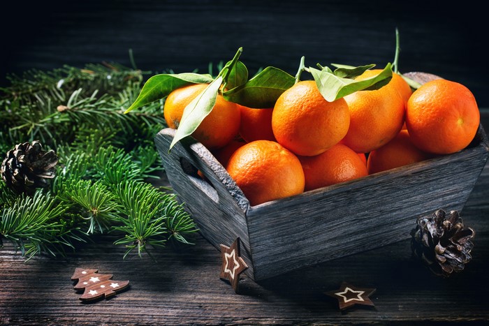 Christmas tangerines in a wooden crate with pine branches