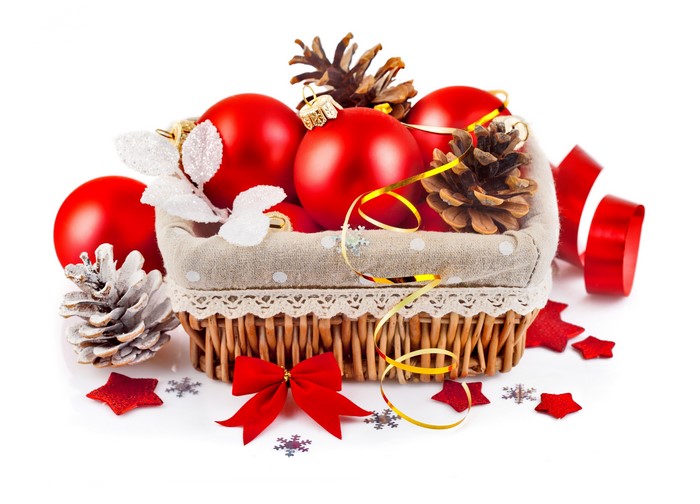 Christmas ornaments in a wicker basket with pine cones and ribbon