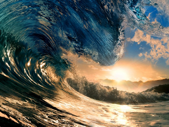 Close-up of a powerful ocean wave crashing at sunset