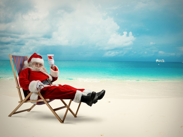 Santa Claus relaxing on a beach with a drink